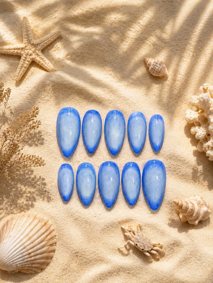 Cloud Kiss — Solid glossy cornflower-blue cat-eye nails, shot on the beach