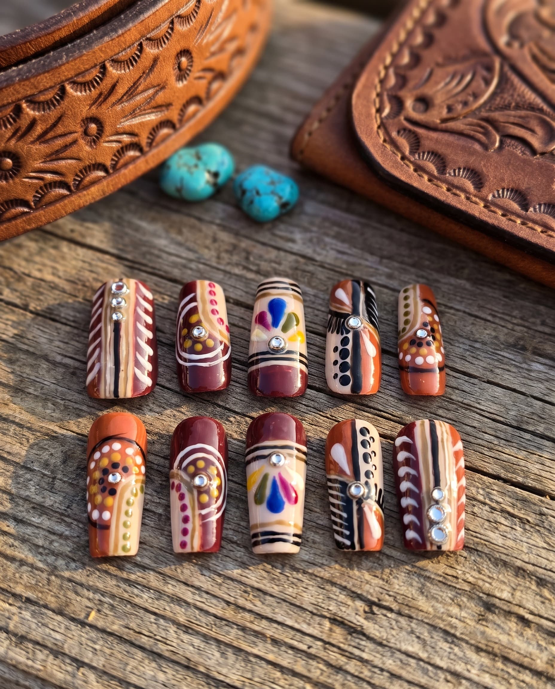 Rust & Turquoise — Maroon, rust and tan with hand-painted wavy lines, dots and small mirror studs, no two nails alike
