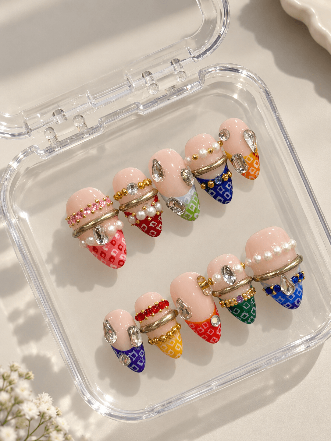 Bejewelled bandhani with bangles — Nude almond nails with rainbow bandhani-print tips, pearls, and crystal gems.