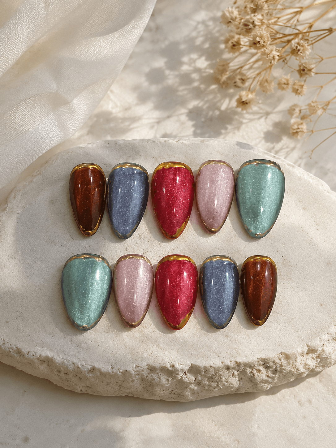 Jewel Cat-Eye Drops — Almond-stiletto nails in five magnetic cat-eye shades with a gold chrome edge.